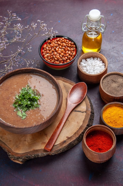 Vista dall'alto zuppa di fagioli marroni deliziosa zuppa cotta con diversi condimenti sulla superficie scura cena zuppa di fagioli colore pasto piccante