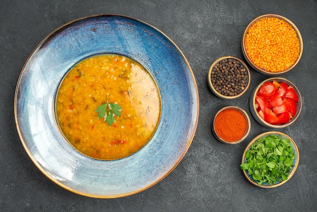 Vista dall'alto zuppa di lenticchie zuppa di lenticchie spezie erbe pomodori lenticchie sul tavolo scuro