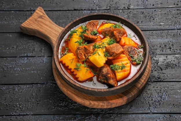 Vista dall'alto zuppa di ragù di carne con patate e verdure sul pavimento scuro