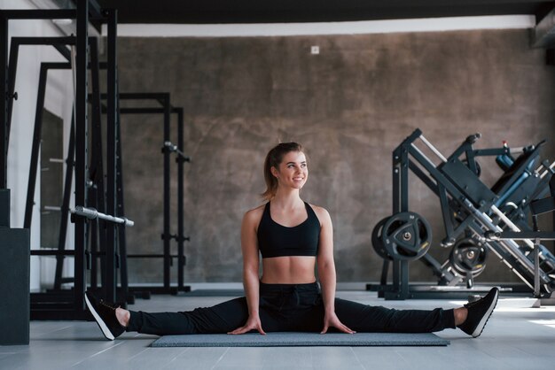 Vista dalla parte anteriore di lei. Foto della splendida donna bionda in palestra durante il fine settimana