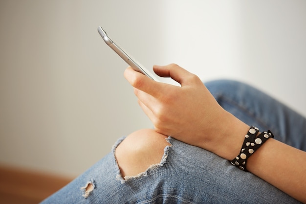 Vista del colpo ritagliata delle mani di una donna che tiene il telefono cellulare