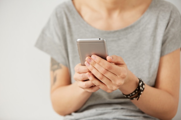 Vista del colpo ritagliata delle mani femminili che tengono il telefono cellulare