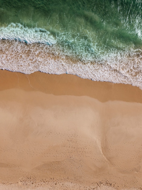 Vista del flusso del mare sulla spiaggia sabbiosa