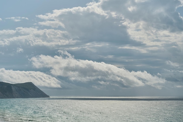 Vista del mare in tempesta e rocce a mezzogiorno sullo sfondo o salvaschermo per lo schermo Nubi sul mare in una tempesta