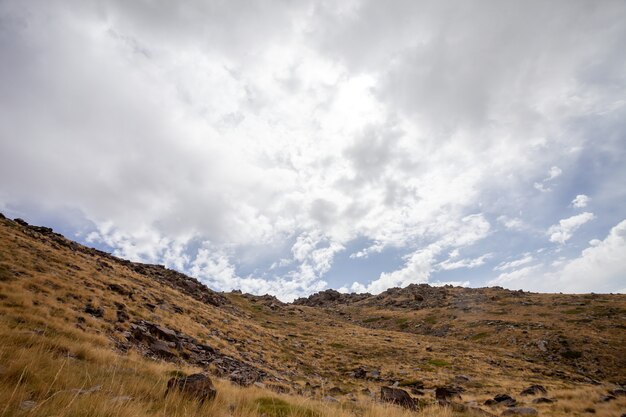 Vista del paesaggio di una collina secca sotto un cielo nuvoloso in Sierra Nevada, Spagna
