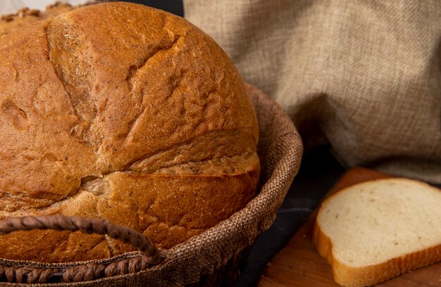 Vista del primo piano del canestro con il pane di pannocchia classico con la fetta del pane bianco