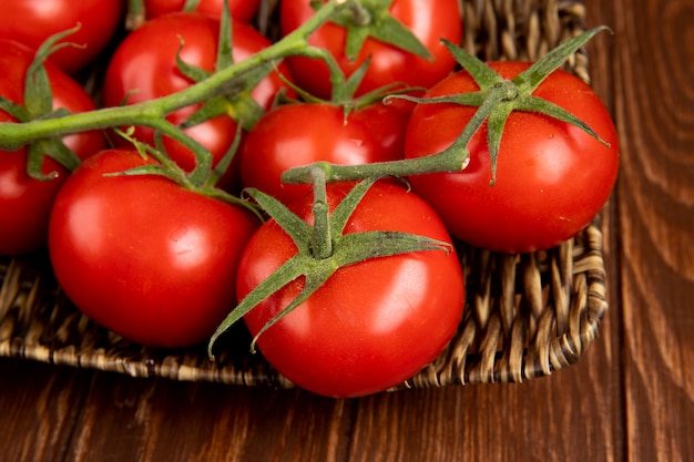 Vista del primo piano del piatto della merce nel carrello dei pomodori sulla tavola di legno