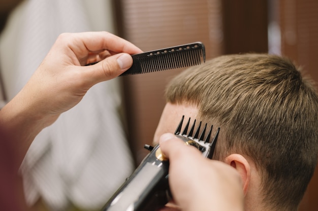 Vista del primo piano dell'uomo che ottiene un taglio di capelli