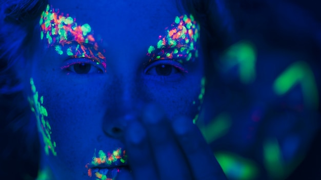 Vista del primo piano della donna con trucco fluorescente variopinto