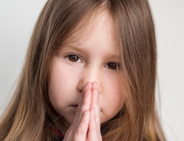 Vista del primo piano di bella preghiera della bambina