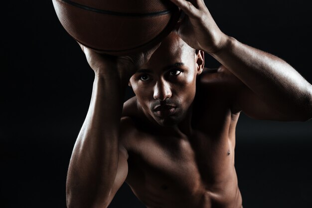 Vista del primo piano di giovane giocatore di pallacanestro afroamericano che prepara gettare palla