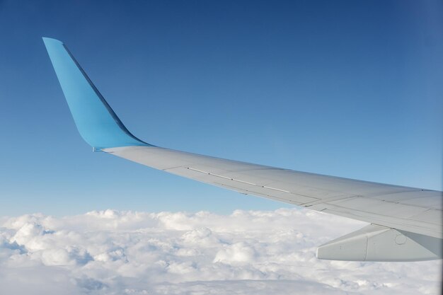Vista dell'ala dell'aeroplano dal sedile del finestrino dell'aeroplano Cielo blu e nuvole