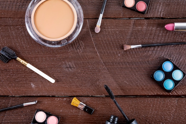 Vista dell&#39;angolo alto dei prodotti cosmetici con le spazzole su fondo di legno