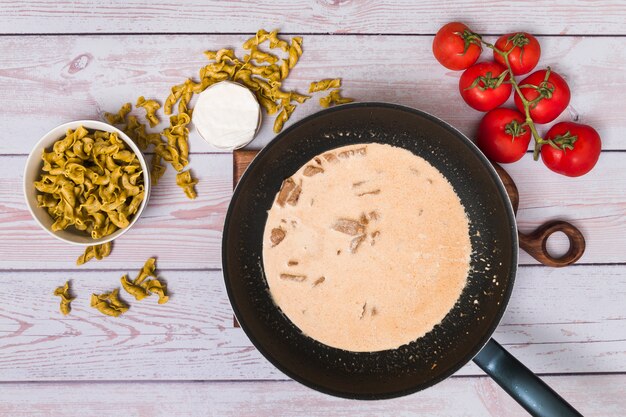 Vista dell&#39;angolo alto di preparazione della pasta saporita italiana sullo scrittorio di legno