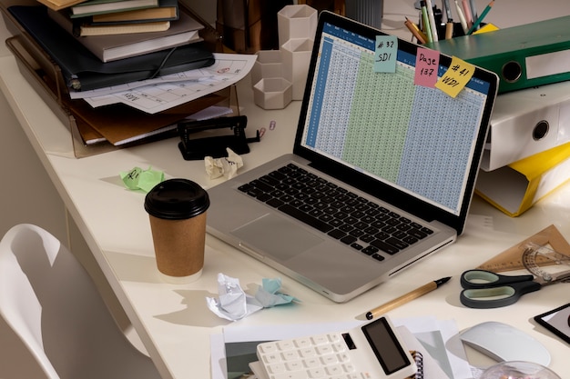 Vista dell'area di lavoro disordinata dell'ufficio con il computer portatile