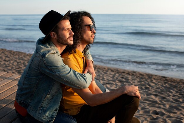 Vista della coppia gay che è affettuosa e trascorre del tempo insieme sulla spiaggia