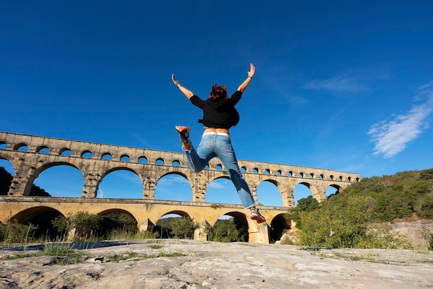 Vista della donna che salta davanti al Pont du Gard
