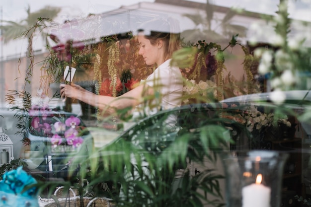 Vista della finestra del negozio floreale con lavoratore