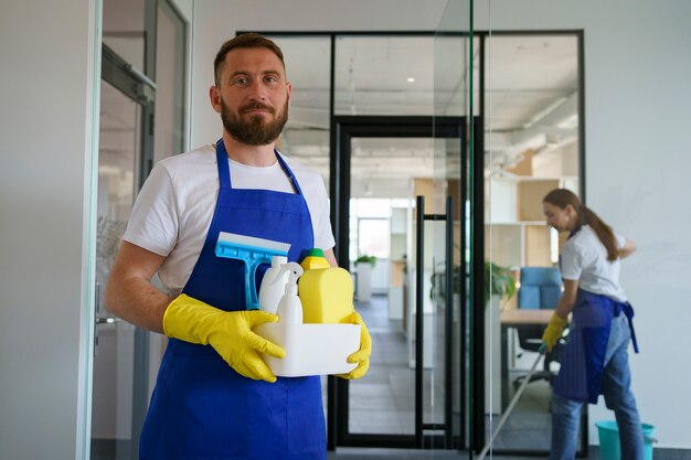 Vista della persona di servizio di pulizia professionale che tiene i rifornimenti