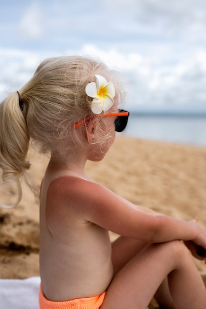 Vista della ragazza con la pelle scottata in spiaggia