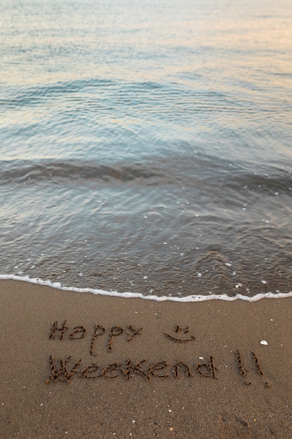 Vista della sabbia della spiaggia in estate con un messaggio scritto su di essa