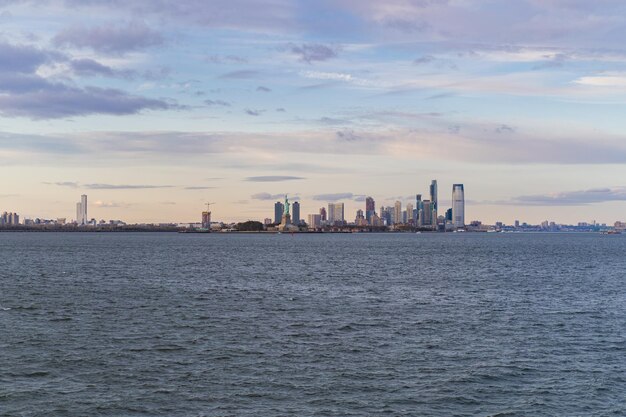 Vista della Statua della Libertà dall'acqua al tramonto, New York, Stati Uniti