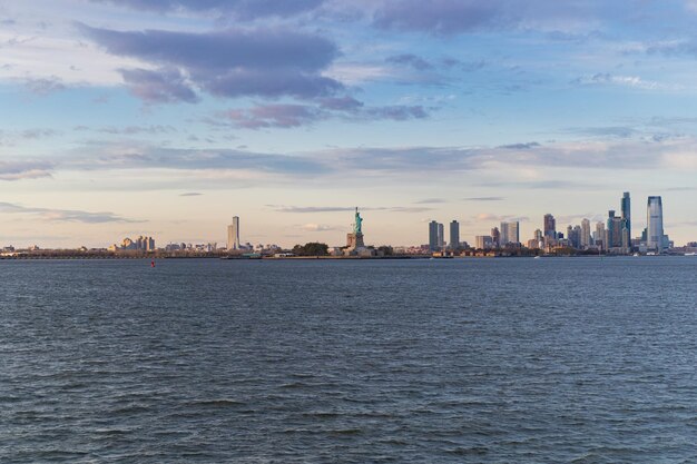 Vista della Statua della Libertà dall'acqua al tramonto, New York, Stati Uniti