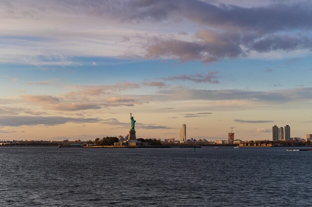 Vista della Statua della Libertà dall'acqua al tramonto, New York, Stati Uniti