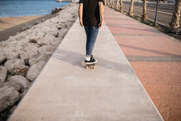 Vista di Lowsection di un uomo che skateboarding sulla parete