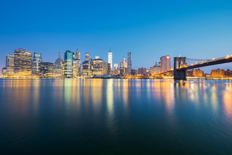 Foto gratuito vista di new york city midtown manhattan al tramonto con grattacieli illuminati su east river