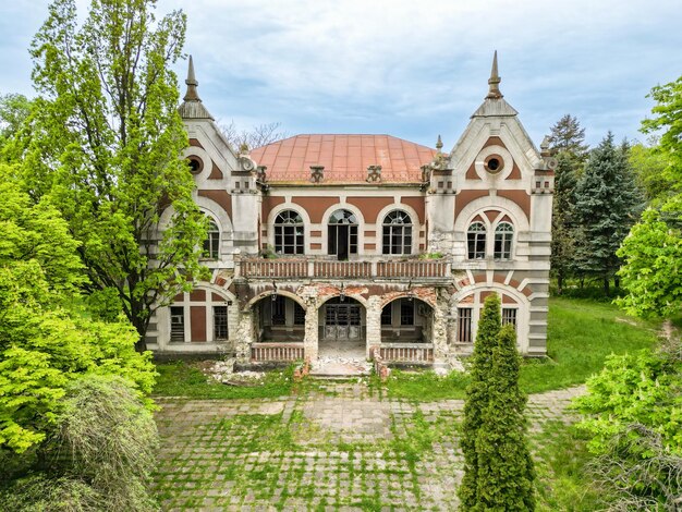 Vista drone della Pommer Mansion a Taul Moldavia Vecchio edificio abbandonato con vegetazione intorno ad esso