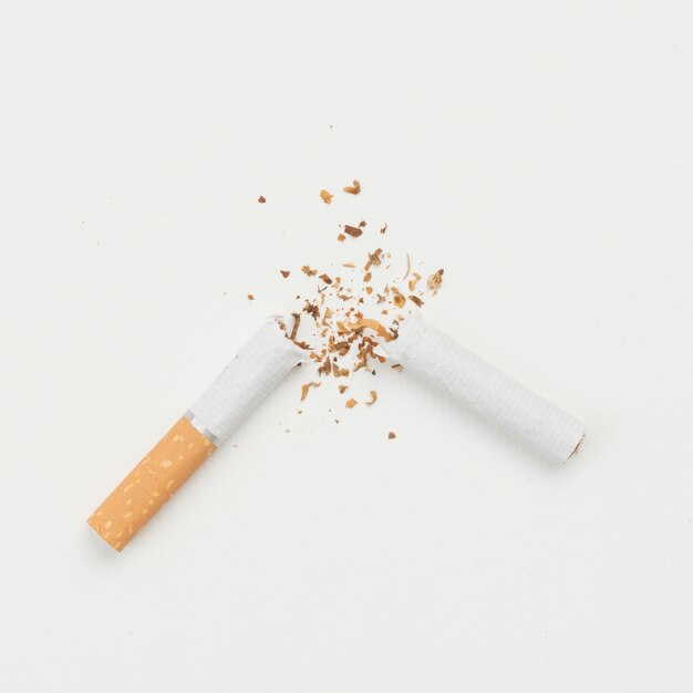 Vista elevata della sigaretta rotta su sfondo bianco