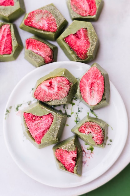 Vista elevata delle caramelle fresche dolci della fragola sul piatto bianco