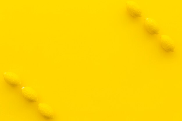 Vista elevata di caramelle al limone su sfondo giallo