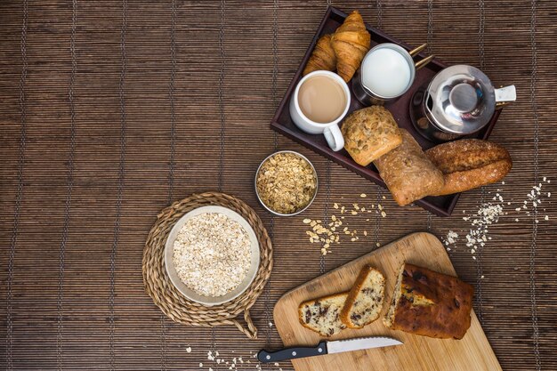 Vista elevata di cibo cotto, tè, latte e avena su tovaglietta