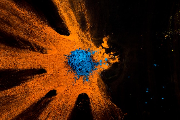 Vista elevata di polvere blu e arancione sulla superficie nera