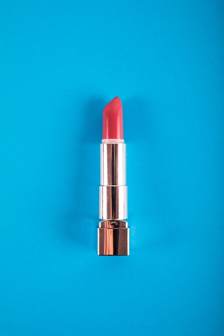 Foto gratuito vista elevata di rossetto su sfondo blu