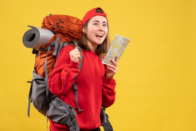 Vista frontale allegro femminile zaino in spalla tenendo la mappa di viaggio