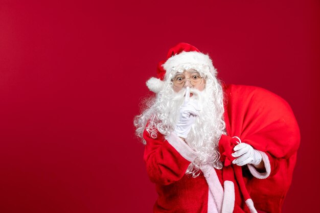 Vista frontale babbo natale borsa da trasporto piena di regali che chiedono di mantenere il silenzio sull'emozione rossa capodanno