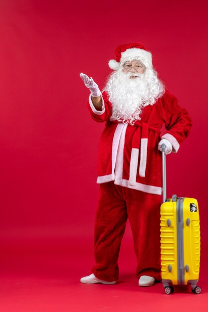 Vista frontale babbo natale che porta una borsa gialla che si prepara per il viaggio