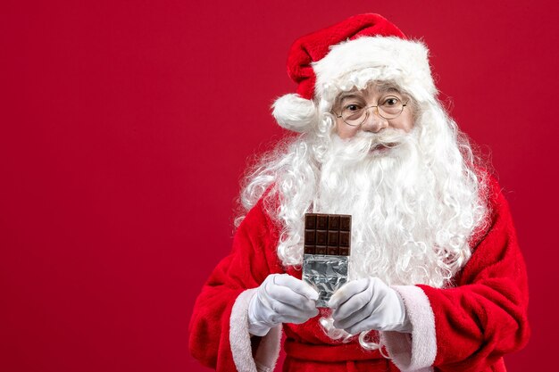 Vista frontale babbo natale che tiene la barretta di cioccolato