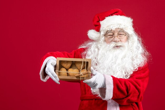 Vista frontale babbo natale che tiene pacchetto con biscotti