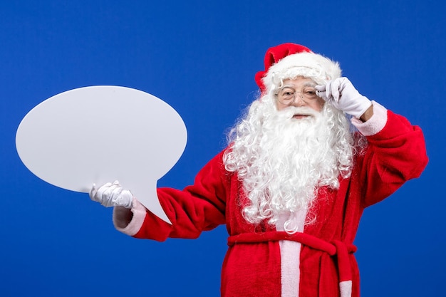 Vista frontale babbo natale che tiene un grande cartello bianco sul colore blu vacanze neve natale