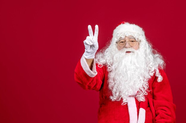 Vista frontale babbo natale con classico orso bianco e vestiti rossi su un rosso natale capodanno