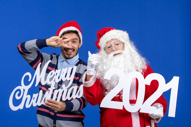 Vista frontale babbo natale con giovane azienda maschio e scritte di buon natale su blue