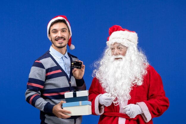 Vista frontale Babbo Natale con i giovani maschi che tengono i regali