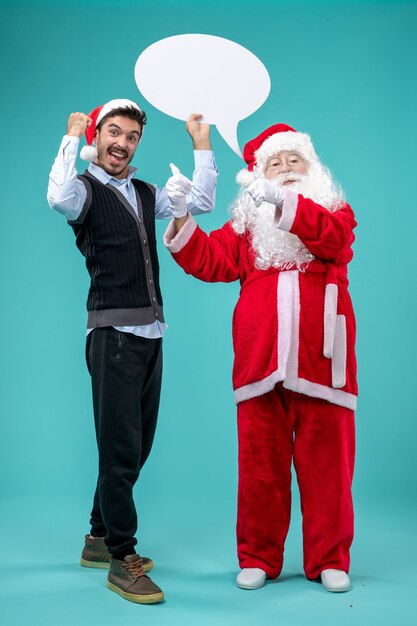 Vista frontale Babbo Natale con il giovane maschio che tiene segno bianco su sfondo blu