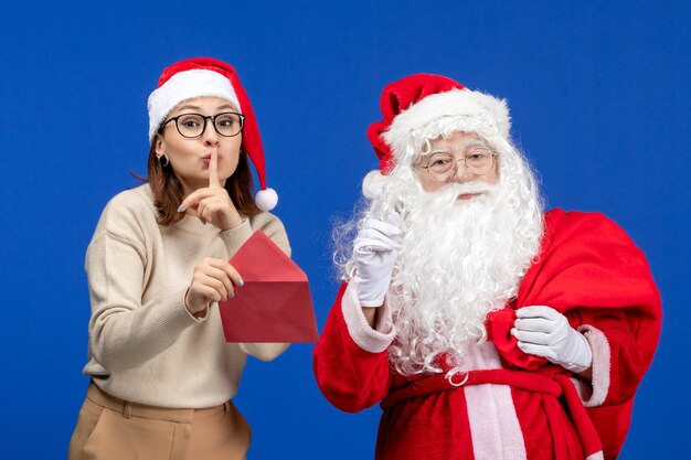 Vista frontale babbo natale e giovane lettera di apertura femminile sull'emozione blu del capodanno di natale di festa