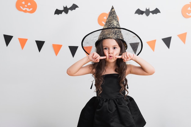 Vista frontale bambina in costume da strega per halloween