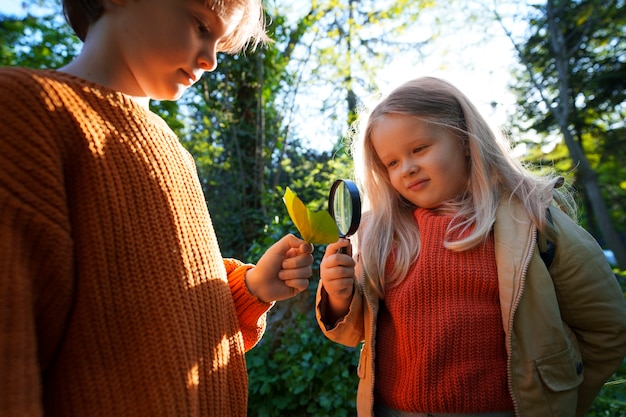 Vista frontale bambini che esplorano la natura insieme